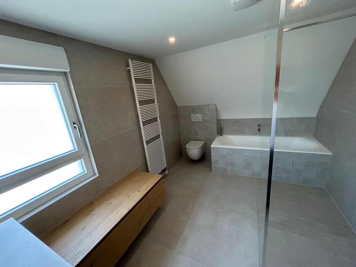 Une salle de bain avec une baignoire, des toilettes et une fenêtre