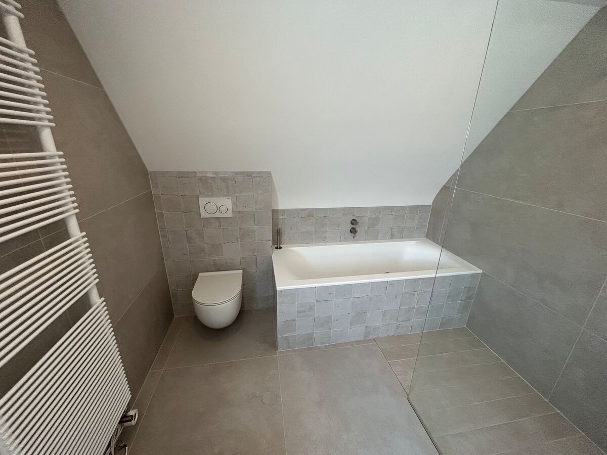 Une salle de bain avec baignoire, toilettes et porte-serviettes