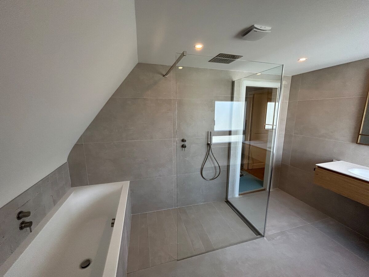 Une salle de bain avec une douche à l'italienne et une baignoire