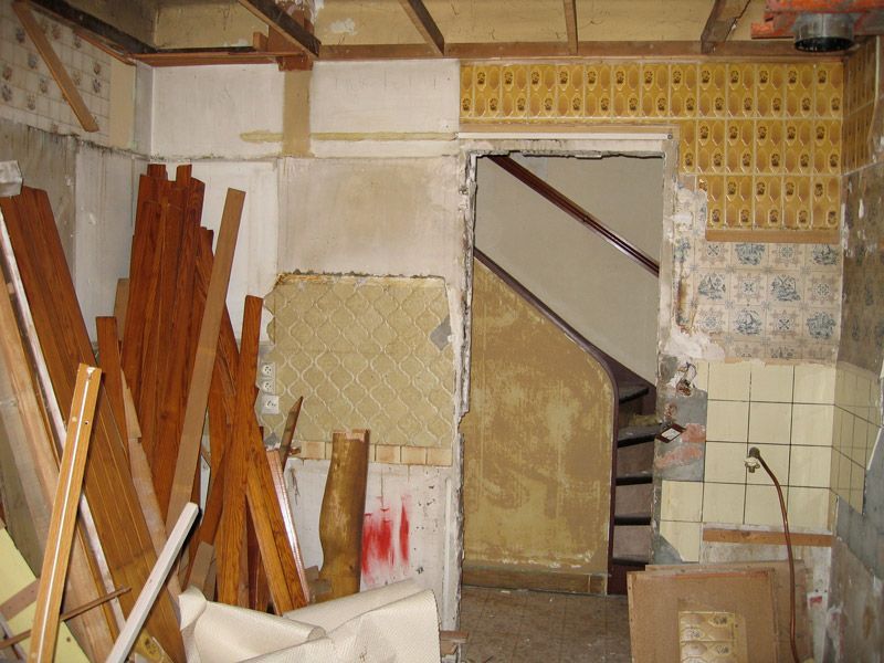 Une pièce en désordre avec un escalier en arrière-plan