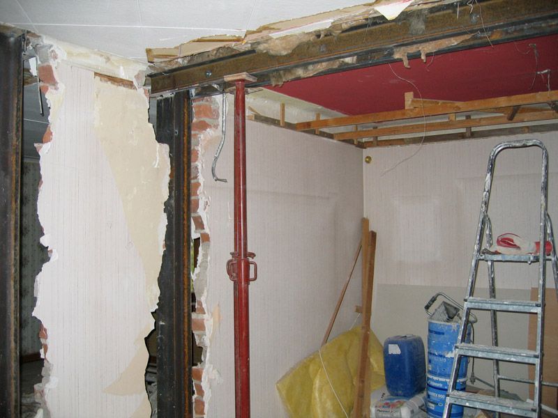 Une échelle se trouve dans une pièce avec un trou dans le mur