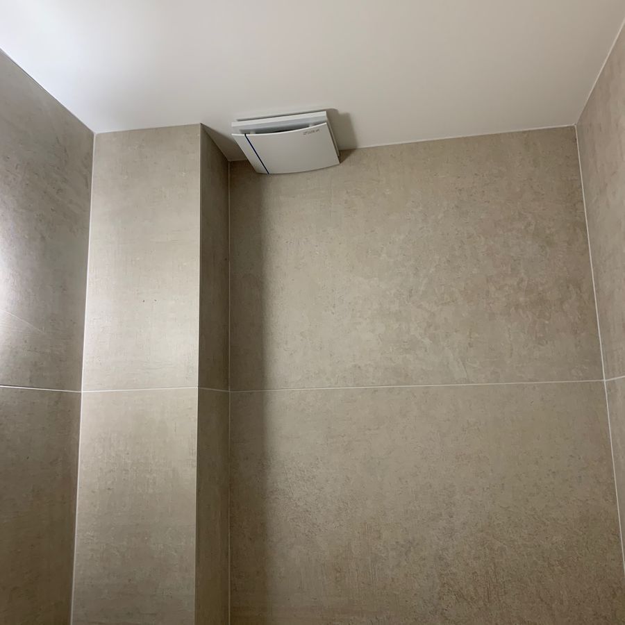 Une salle de bain avec un ventilateur de plafond suspendu au plafond.
