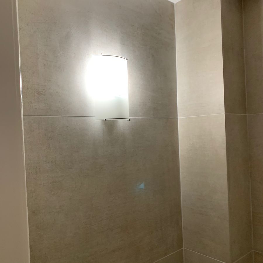 Il y a une lumière sur le mur dans la salle de bain.