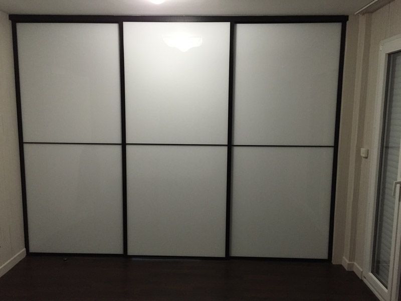 Une pièce avec une porte coulissante en verre et des murs blancs.