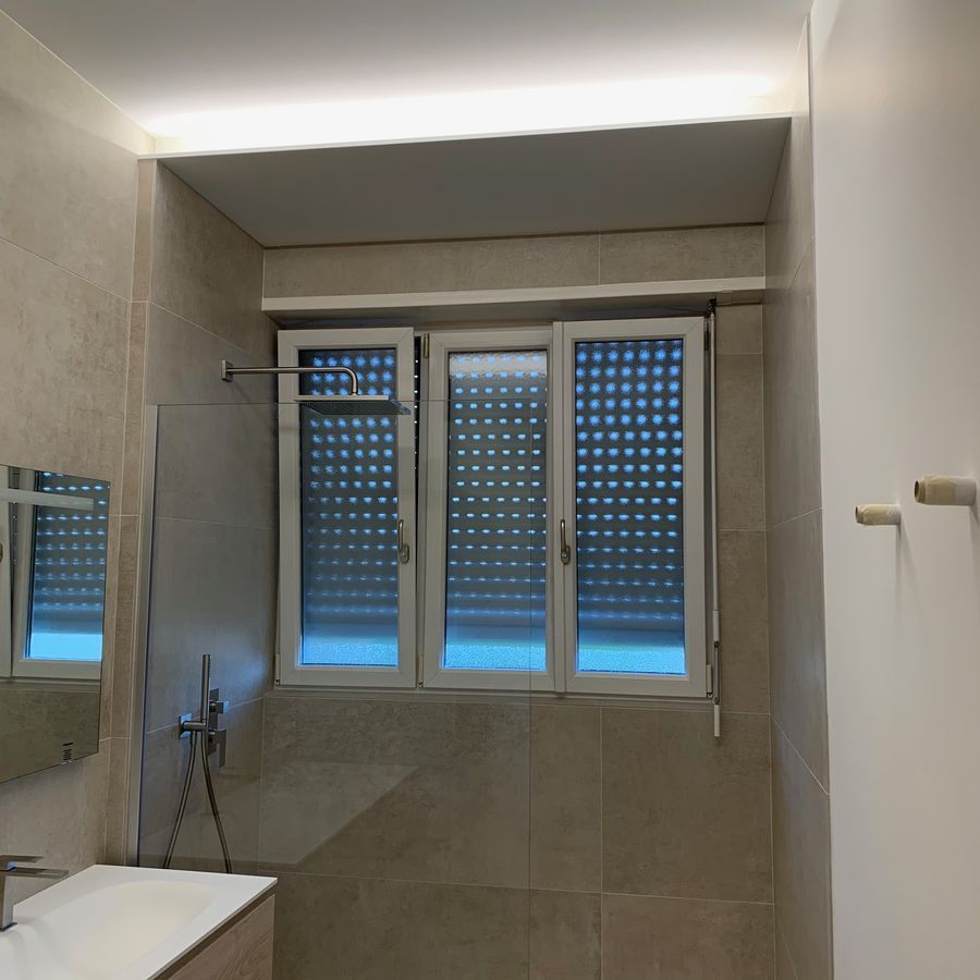 Une salle de bain avec trois fenêtres et un lavabo