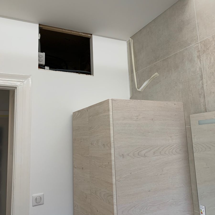 Une salle de bain avec une armoire en bois et un miroir