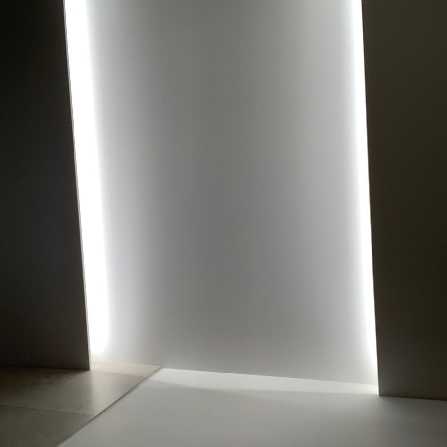 Un mur blanc traversé par une lumière