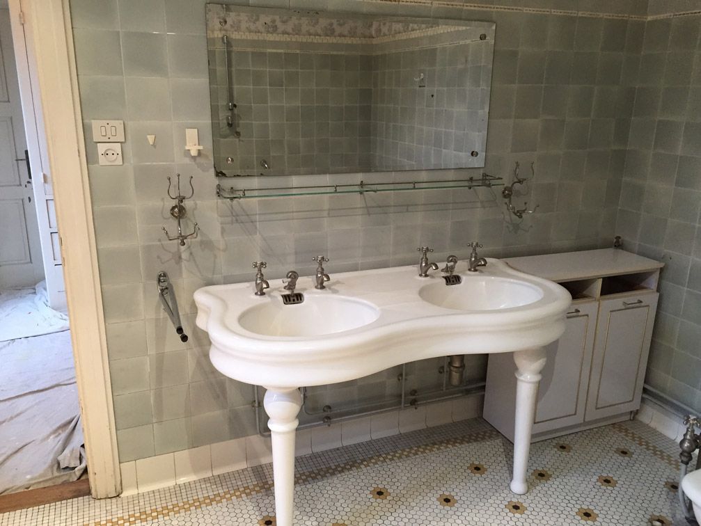 Une salle de bain avec deux lavabos et un miroir.