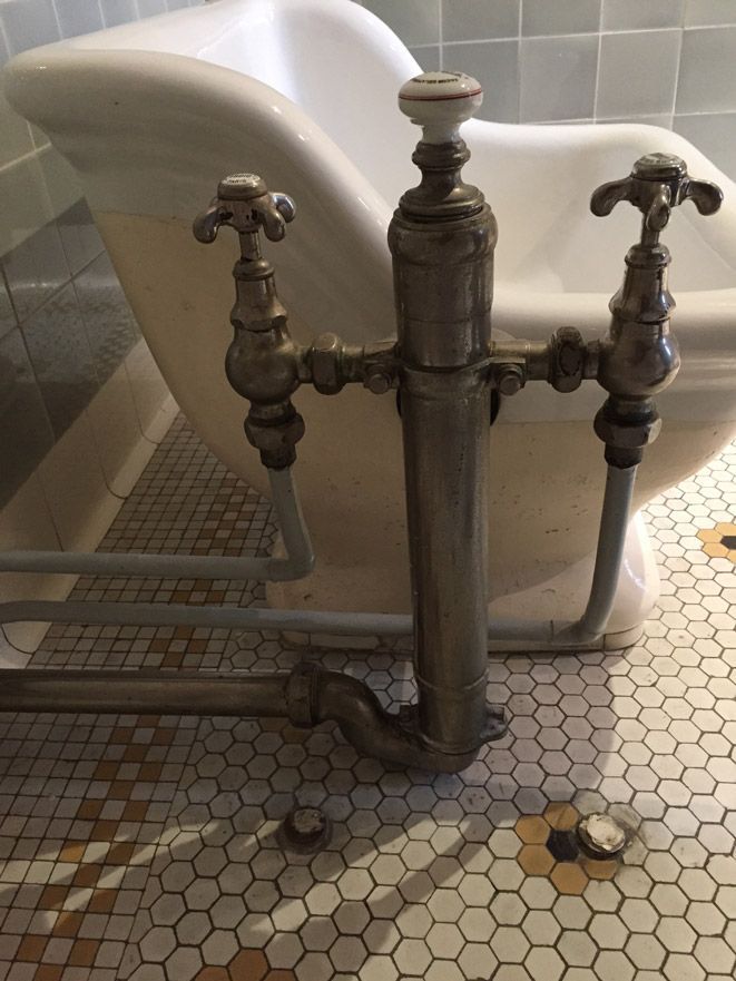 Une salle de bain avec une baignoire et un robinet au sol