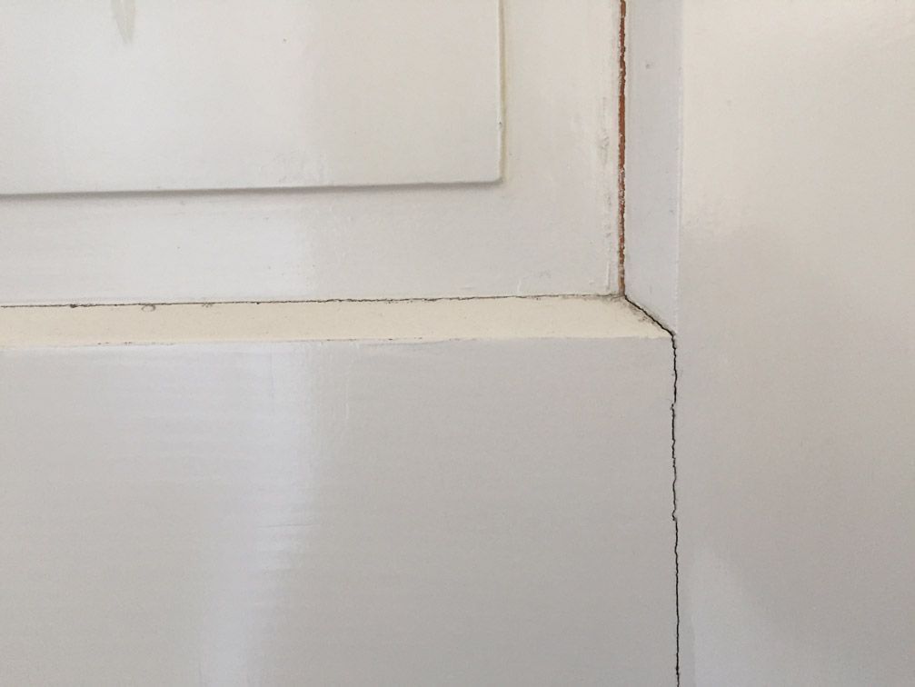 Un gros plan d'un mur blanc avec un miroir dessus.