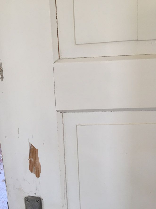 Un gros plan d'une porte blanche avec un trou dedans.