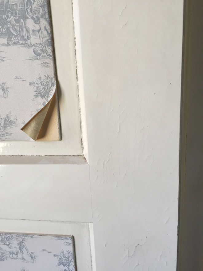 Un gros plan d'une porte blanche avec un morceau de papier peint dessus.