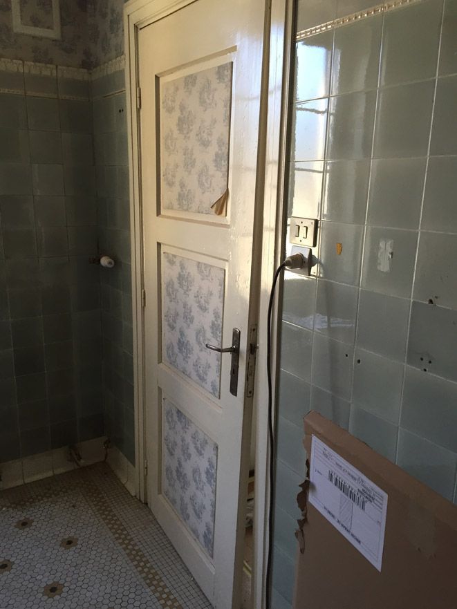 Une salle de bain avec une porte blanche et une boîte au sol