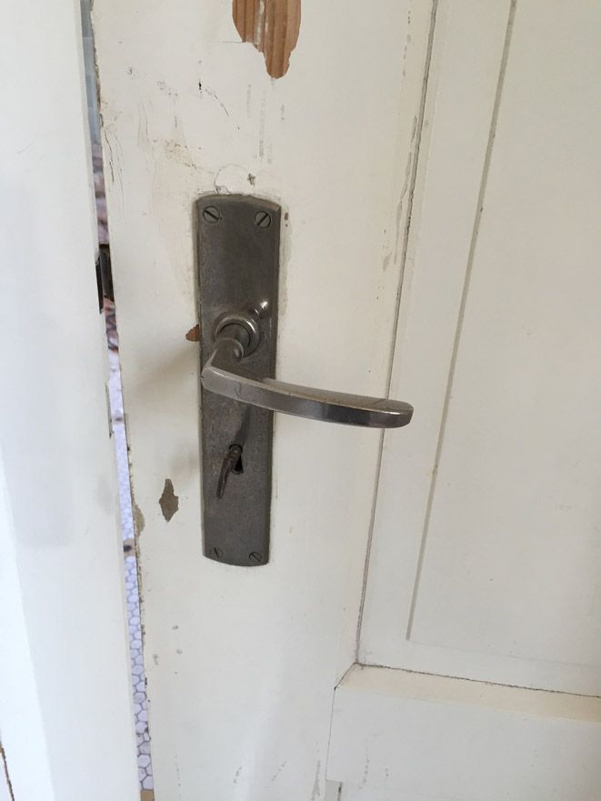 Un gros plan d'une poignée de porte sur une porte blanche