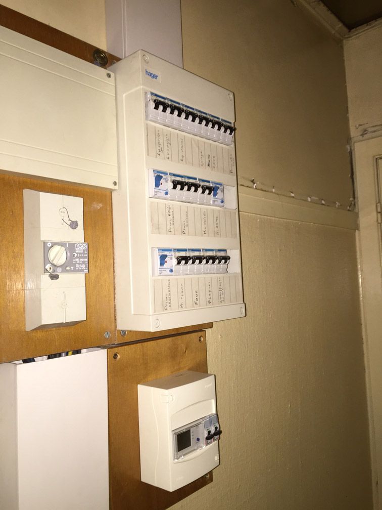 Un boîtier électrique est accroché au mur d'une pièce.