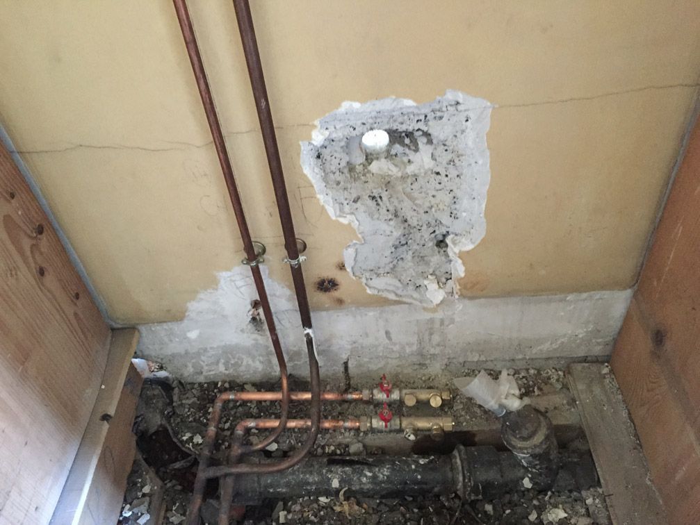 Un trou dans le mur avec des tuyaux qui en sortent.