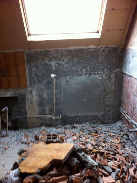 Une pièce avec une lucarne et beaucoup de briques au sol