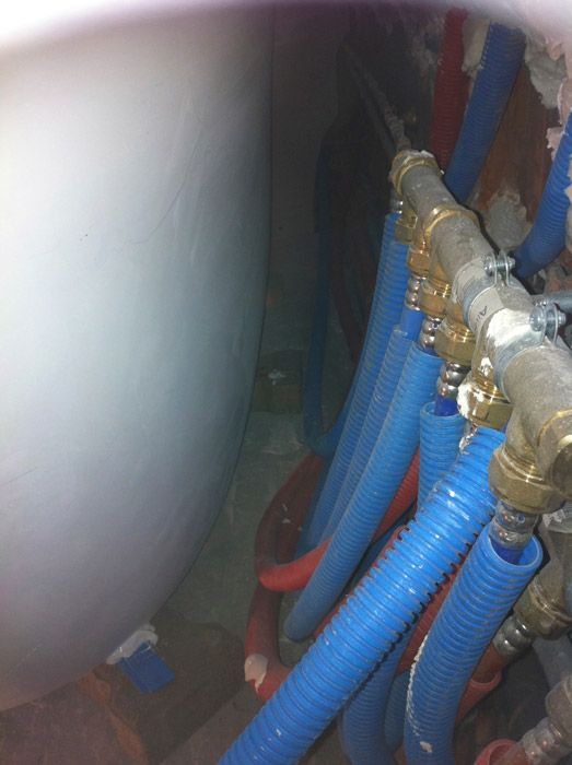 Un tas de tuyaux bleus sont reliés à un réservoir blanc.