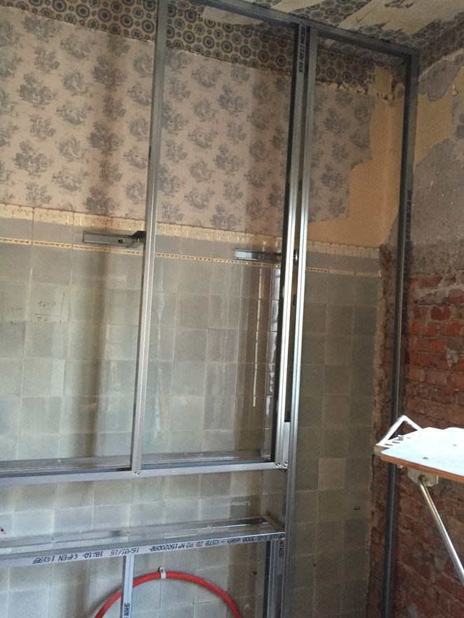 Une pièce avec un mur de briques et une planche à repasser