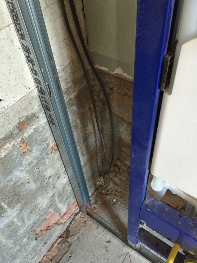 Un cadre bleu est en train d'être intégré dans un mur de briques