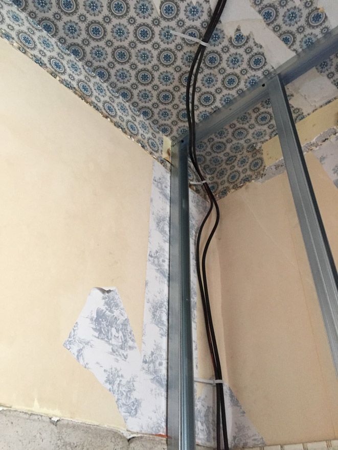 Un coin d'une pièce avec un plafond sur lequel est posé un motif.