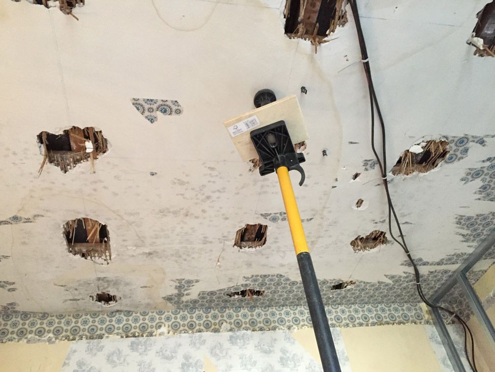 Un plafond avec des trous et un poteau jaune