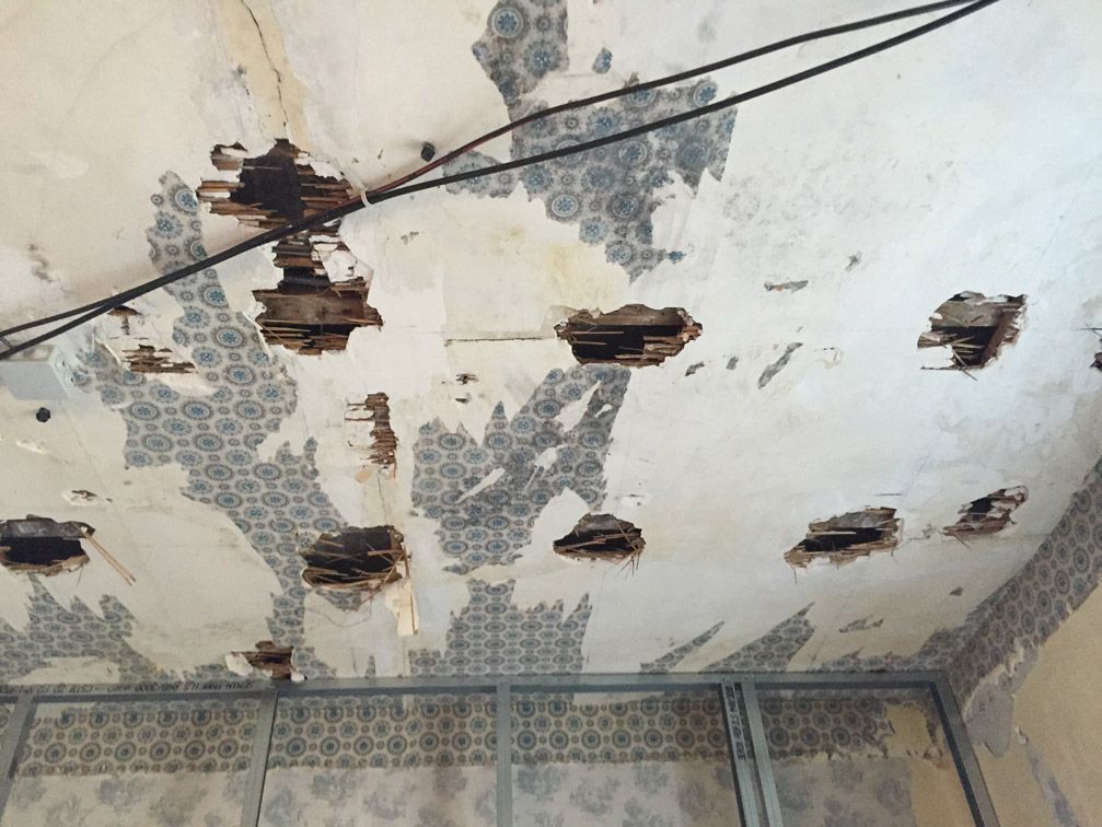 Un plafond avec des trous et des fils qui y pendent