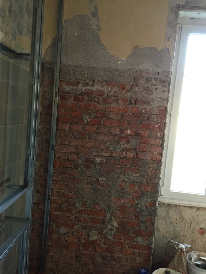 Une pièce avec un mur de briques et une fenêtre