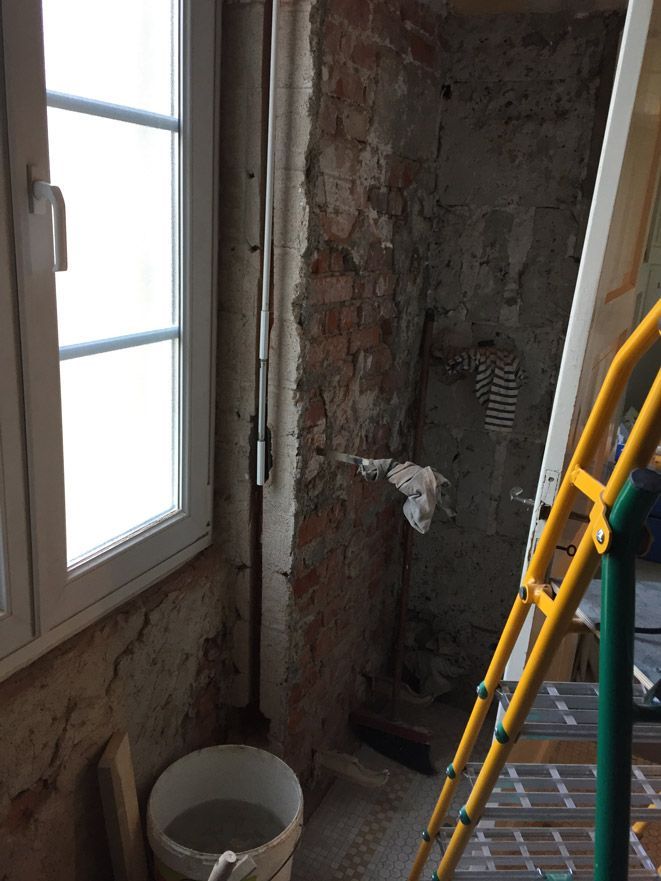 Un seau d'eau se trouve dans une pièce à côté d'une échelle.