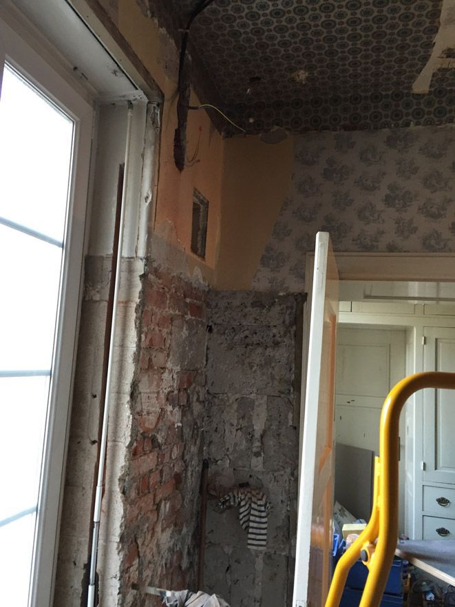 Une échelle jaune se trouve dans une pièce à côté d'une fenêtre.