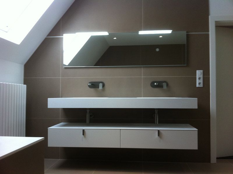 Une salle de bain avec deux lavabos et un grand miroir