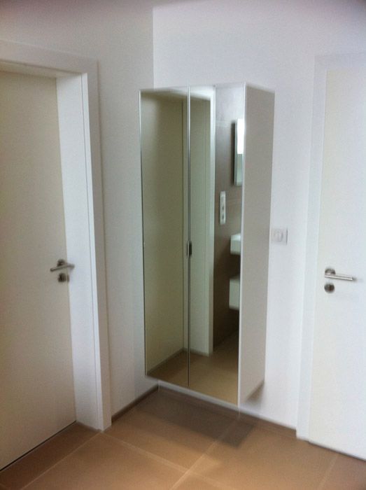 Une pièce avec un miroir sur le mur et une porte