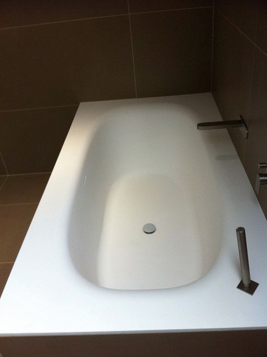 Une baignoire blanche dans une salle de bain avec un robinet