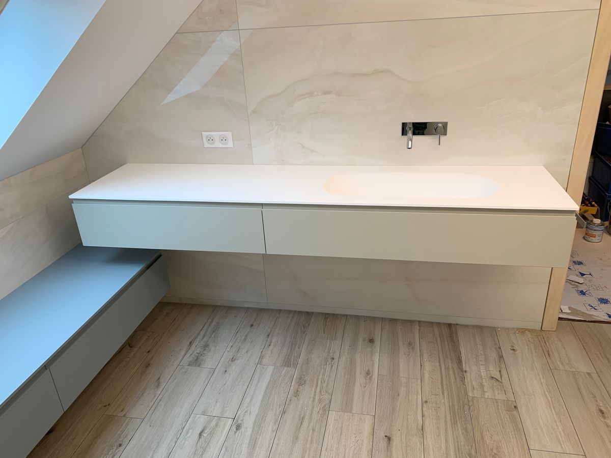 Une salle de bain avec un lavabo et un plancher en bois.