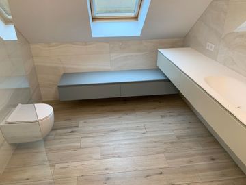 Une salle de bain avec WC, lavabo et puits de lumière.