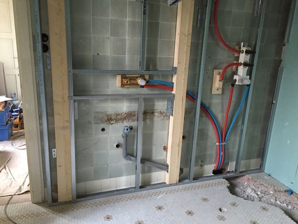 Une salle de bain en construction avec des tuyaux sortant du mur