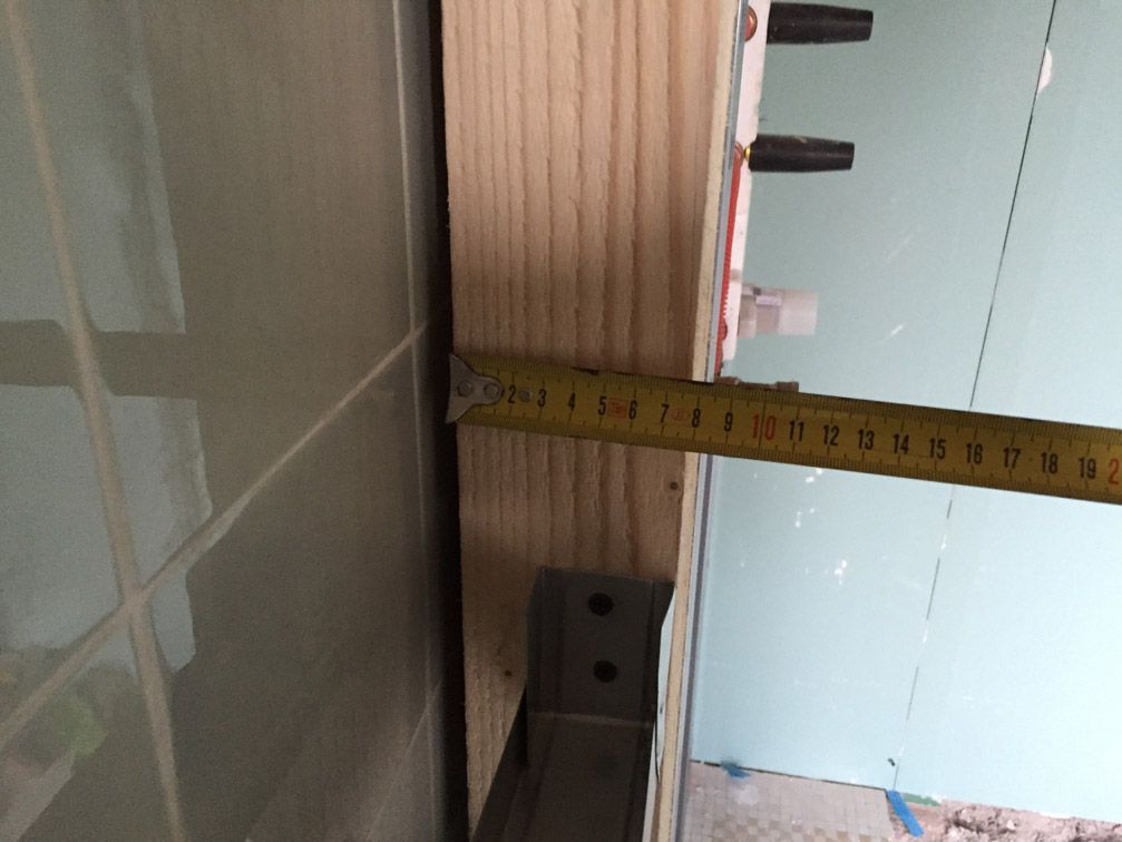 Un ruban à mesurer jaune est utilisé pour mesurer un morceau de bois