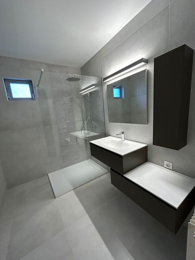 Une salle de bain avec deux lavabos et une douche à l'italienne