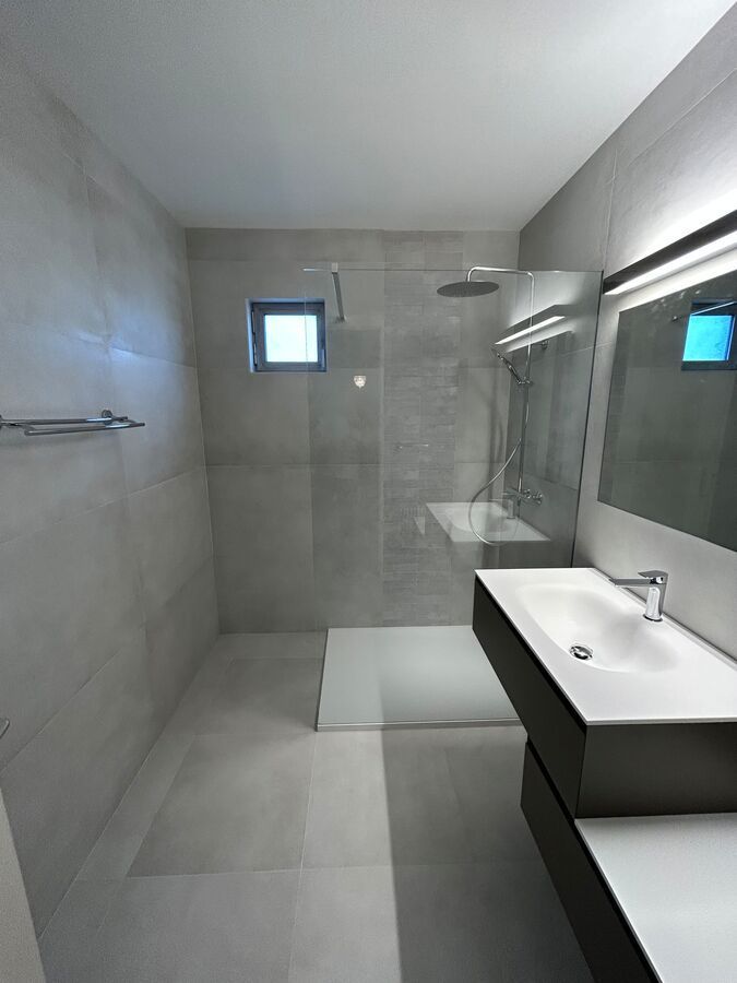 Une salle de bain avec une douche à l'italienne et un lavabo