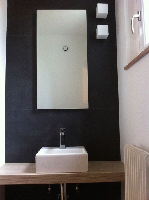Une salle de bain avec un lavabo et un miroir au mur