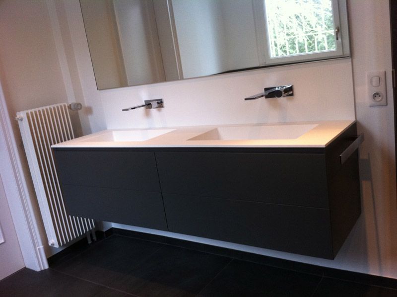 Une salle de bain avec deux lavabos et un miroir