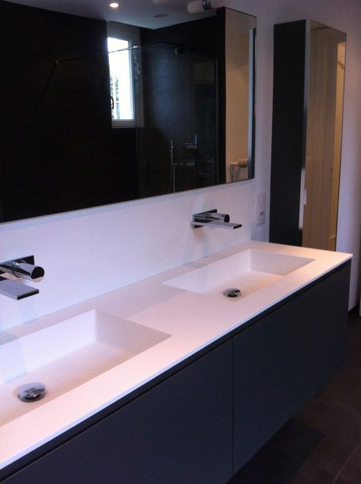 Une salle de bain avec deux lavabos et un grand miroir