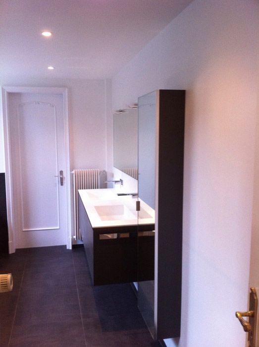 Une salle de bain avec deux lavabos et un miroir