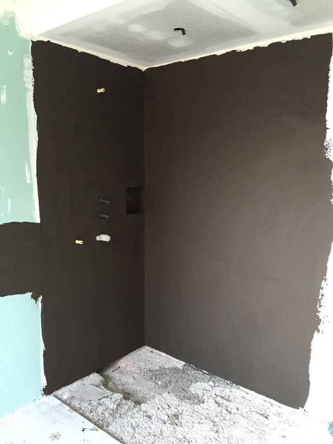 Un coin d'une pièce qui est en train d'être peint en noir