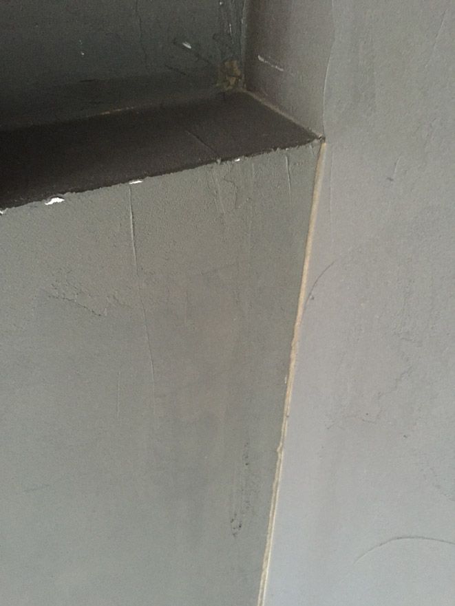 Un gros plan d'un coin d'un mur dans une salle de bain.