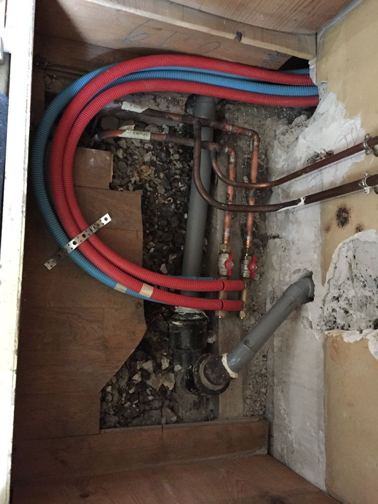 Un tas de tuyaux sont reliés à un mur dans une pièce.