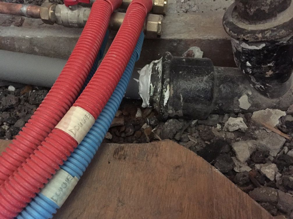 Un tas de tuyaux sont posés sur le sol et l'un d'eux porte une étiquette indiquant super