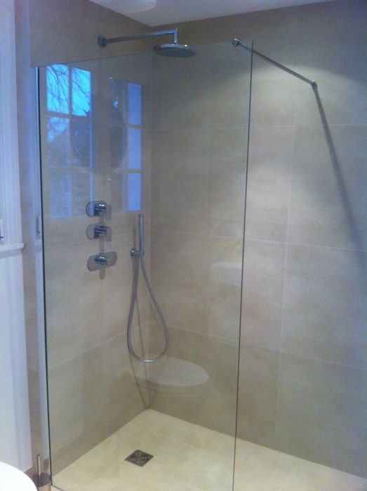 Une salle de bain avec une douche à l'italienne avec une porte vitrée