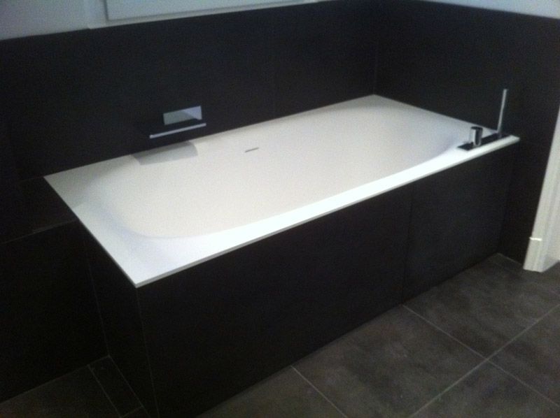 Une baignoire dans une salle de bain avec un mur noir