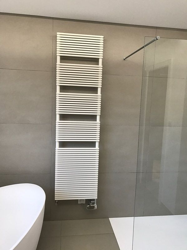 Une salle de bain avec une baignoire et un porte-serviettes au mur.